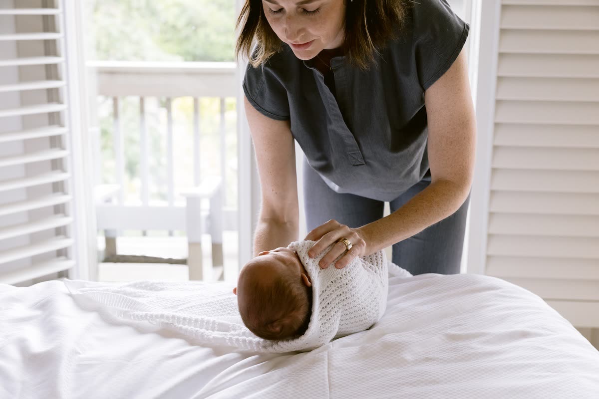 A newborn being swaddled with care during a Cassiana stay